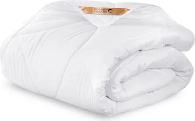 A white comforter is folded and presented on a white background.