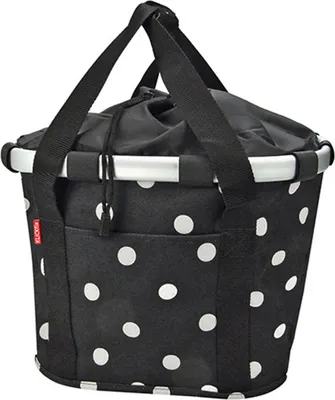 A black and white polka dot bicycle basket with silver trim and black straps.