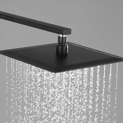 A close-up view of a black square shower head with water spraying from it.