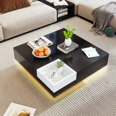 A modern living room scene featuring a black coffee table with a white tray and decorative items, placed on a striped rug.