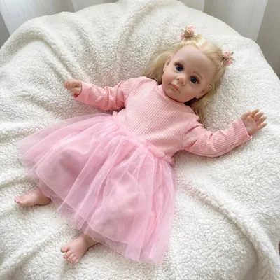 Produktbild von 55 Cm Große, Aus Baumwolle Gefertigte Puppe Mit Blauen Augen, Transplantierten Haaren, Angeklebten Wimpern, Einem Rosa Gestreiften, Langärmeligen Tüllkleid Und Zwei Rosa Haarspangen In Kronenform – Lebensechte Puppe