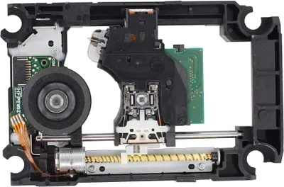 A close-up view of a PlayStation 4 disc drive mechanism, showing the laser assembly, motor, and gears.