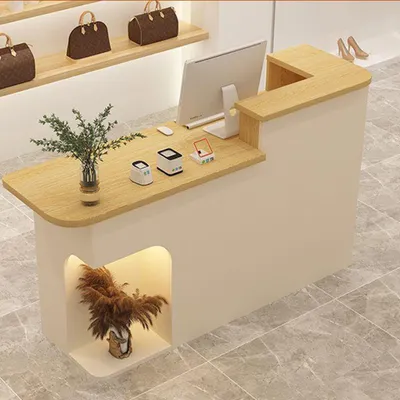 A retail counter in a store with bags displayed on shelves above.