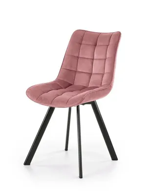 A pink velvet chair with black legs is shown against a white background.