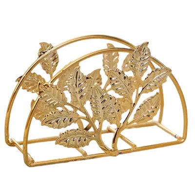 A gold-colored metal napkin holder with a leaf design.