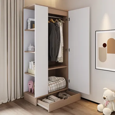 A wardrobe with its doors open, showing clothes hanging inside and shelves with items. A drawer is pulled out at the bottom. A teddy bear and a framed picture are visible in the background.