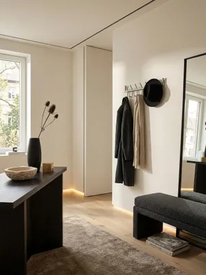 Draufsicht auf einen stilvoll eingerichteten Flur mit der 60 cm breiten Hakenleiste aus Metall, die als zentrales Organisationselement an der Wand montiert ist._#sku_SAFWL6.444#