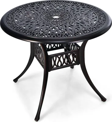 A round, dark brown, cast aluminum outdoor dining table with an ornate, openwork design on the tabletop and a decorative, lattice-like pattern on the base.