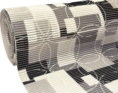 A rolled-up bath mat with a geometric pattern.