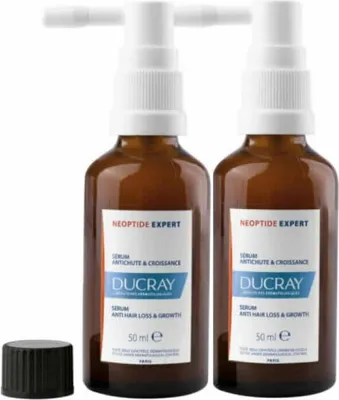 Two bottles of Ducray Neoptide Expert Serum Anti Hair Loss & Growth are displayed side-by-side on a white background, with a black cap to the left.