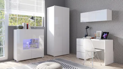 A modern white bedroom set including a desk, cabinet, and wardrobe, set against a patterned wallpaper.