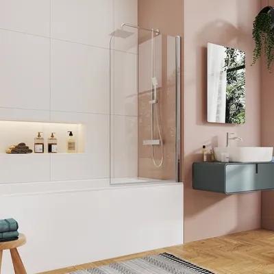 A modern bathroom with a bathtub, shower screen, and vanity. The shower screen is partially open, showing the shower head and controls. The vanity has a sink and a mirror above it. There are also some decorative items on a shelf.