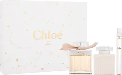 A gift set of Chloé perfume, including a large bottle, a smaller bottle, and a travel-sized spray, presented in a white box with gold constellation designs.