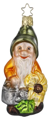 Ein gläserner Weihnachtsbaumschmuck in Form eines Zwergs mit grüner Mütze, einer silbernen Gießkanne und einer großen Sonnenblume.