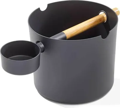 A black sauna bucket with a wooden handle and a small attached cup.