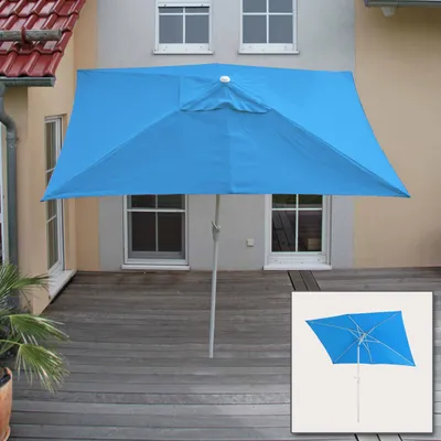 A blue rectangular umbrella is set up on a wooden deck in front of a house with windows.
