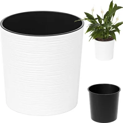 A white planter with a black inner pot and a small plant in a white pot.