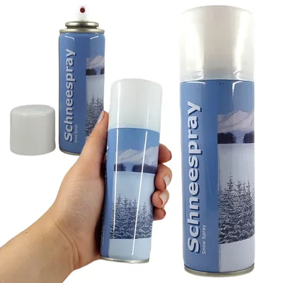 A hand holding a can of snow spray with a snowy landscape on the label. Another can and its cap are visible in the background.