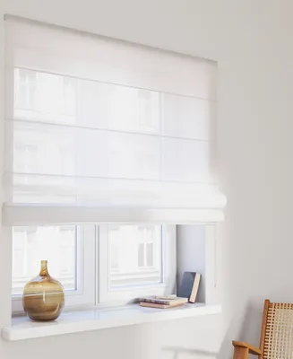 A white Roman blind covering a window, with a vase and books on the windowsill below.