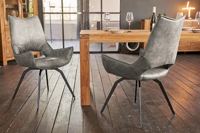 Two gray dining chairs are placed next to a wooden dining table in a modern dining room.