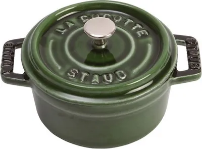 A green Staub cocotte pot with a silver knob on a white background.