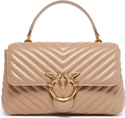 A beige quilted handbag with gold bird hardware.