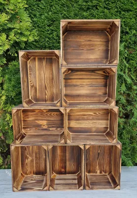 A stack of wooden crates against a green leafy background.