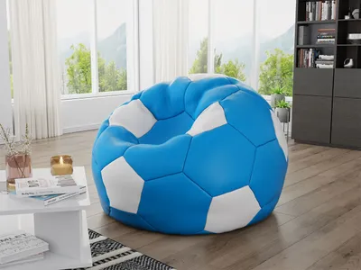 A blue and white soccer ball-shaped beanbag chair is placed in a living room with a large window overlooking a green landscape.