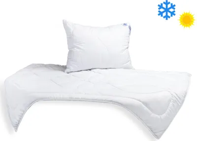 A white pillow and comforter set on a white background.