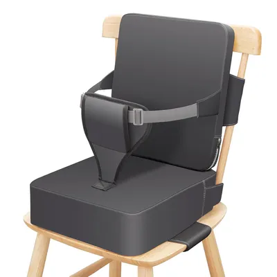 A gray toddler booster seat is placed on a wooden chair.