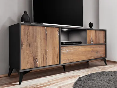 A modern TV stand with a wood grain finish and black accents, featuring storage compartments and drawers. A television is placed on top.