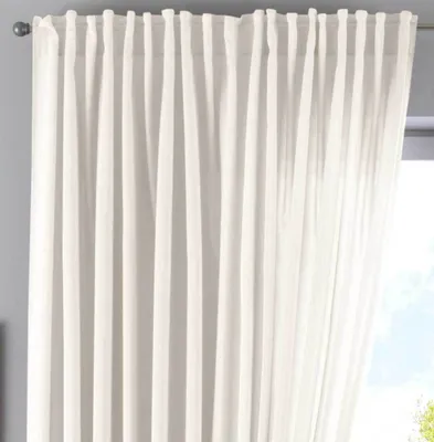 A close-up view of a white curtain hanging from a rod.