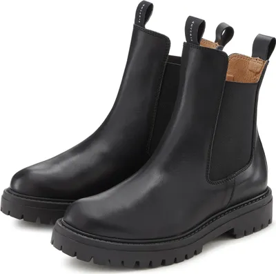 A pair of black leather Chelsea boots with thick soles are shown against a white background.