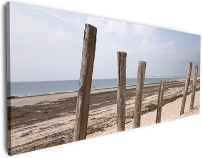Produktbild von Wallario Premium Leinwandbild Sandstrand mit Holzpfählen am Atlantischen Ozean in Größe 60 x 150 cm