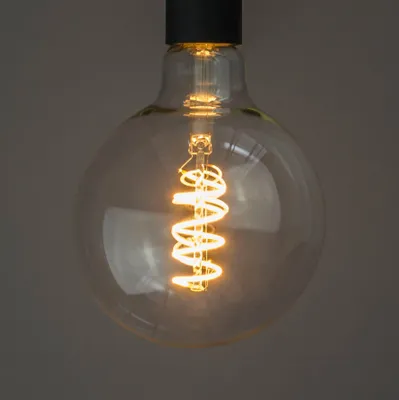 A close-up shot of a vintage-style LED light bulb with a spiral filament.