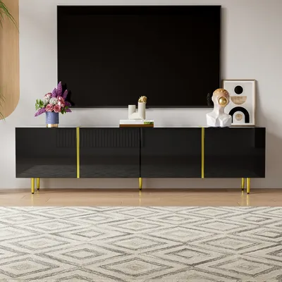 A modern living room setup with a black high-gloss TV stand and a large television.