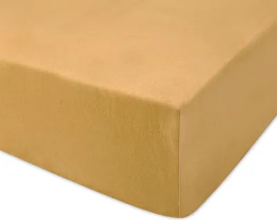 A close-up, angled view of a mustard yellow fitted sheet.