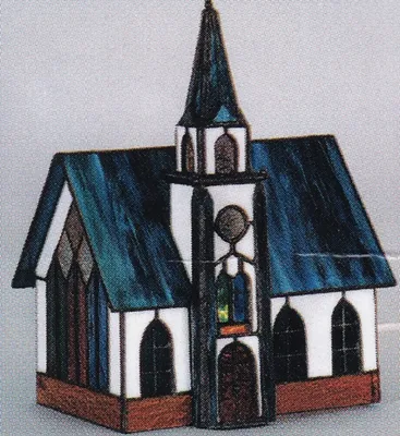 Tiffanykirche mit dunkelblauen Dach weiße Wände. Kirchturm ist hoch und spitz. Fenster mehrfarbig.