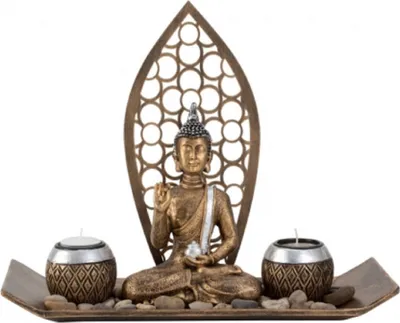 Eine goldene, detaillierte Buddha-Statue, die auf einer Ablage mit zwei Teelichthaltern sitzt.