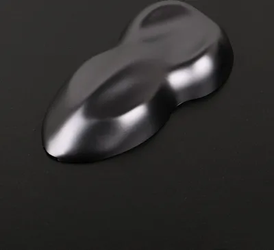 A matte dark gray car wrap sample is shown on a black surface.
