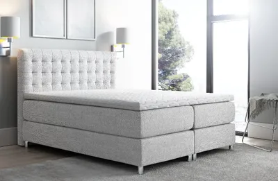 A modern bedroom with a large bed and a window.