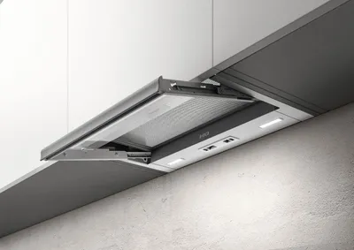A close-up view of a modern kitchen range hood integrated into a cabinet.