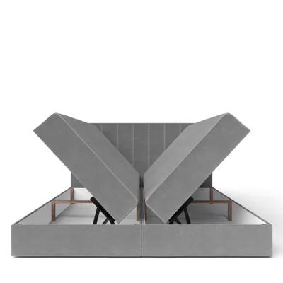 A grey upholstered bed frame with the storage compartments open, revealing the internal mechanism and storage space.