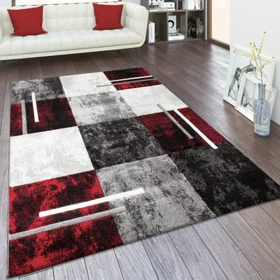 A modern living room with a white sofa and a geometric rug.