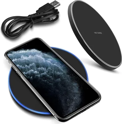 A black wireless charger with a phone on it, and a charging cable.
