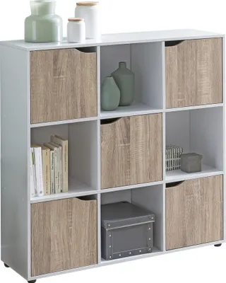 A white cube storage unit with wooden doors and open shelves, containing books, vases, and a storage box.