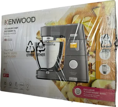 The image shows the packaging of a Kenwood stand mixer, with the mixer itself visible through the plastic wrap.