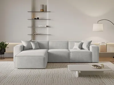 A modern living room with a light gray sectional sofa and a coffee table.