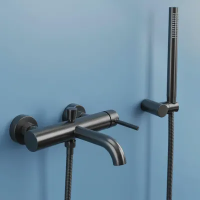 A black bathtub faucet and showerhead mounted on a light blue wall.