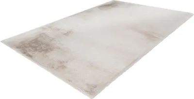 A beige rug with brown abstract patterns is shown from a diagonal angle against a white background.